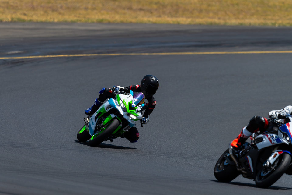 Motorcyclists riding through a sweeping race-track bend